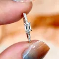 Elegant emerald-cut simulated diamond ring featuring pavé stones on a sleek silver band - US Size 5 / White Gold