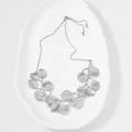 Detailed view of silver-colored zinc alloy leaf pendant necklace on white ceramic - Leaf Necklace / Silver