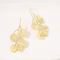 Detailed view of gold leaf drop earrings with intricate matte texture on white tray. - Leaf Earrings / Gold