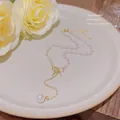 Elegante goldfarbene Titanstahl-Halskette mit kleinen Perlen und einem stilvollen Schleifenanhänger - Schleifen-Kunstperlen-Stil (X136) / Gold