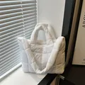 Dettaglio della borsa a nuvola imbottita bianca con texture soffice su un davanzale luminoso - Bianco