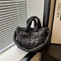 Vista dettagliata di una borsa trapuntata nera in un ambiente interno minimalista - Nero