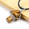 Macro detail of handmade wire wrapped tiger's eye mushroom pendant on wooden background - Tiger's Eye