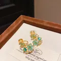Close-up of elegant 18k gold plated flower earrings with blue and green zircons - Ear Clip (HE28297-3) / Blue