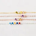 Detailed view of personalized birthstone bracelets with colorful round zircons - Gold