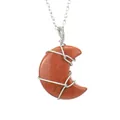 Close-up of handmade wire wrapped moon pendant necklace in orange goldstone finish - Gold Sandstone