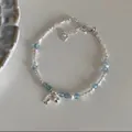 Silver charm bracelet featuring blue beads, pearls and a delicate silver fish tag - Silver Blue Stone Fish Pendant Style