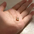 Detailopname van een gouden halsketting met een glanzende hartvormige hanger - Lichtgeel