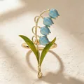 Close-up of luxury lily of the valley napkin ring with exquisite blue enamel flowers and green leaves - Blue