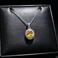 Detailed close-up of a yellow oval moissanite pendant necklace in a black box. - Pendant Necklace (T16) / Yellow
