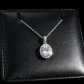 Detail view of oval cut moissanite pendant with halo diamonds on textured jewelry box. - Pendant Necklace (T16) / White