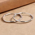 Detailed macro view of minimalist large silver hoop earrings on a rustic tan background - Smooth Hoop Earrings / 6cm / Silver