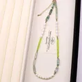 Detalle de collar de perlas naturales de lujo con cristales verdes y cuentas de jade - Collar / 40+5cm / Dorado