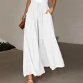 Detail of white wide-leg trousers featuring a high elastic waist with a drawstring tie. - White