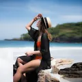 Detail view of a black chiffon crinkle beach cover-up worn over an orange bikini - One Size / Tops / Black