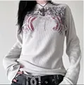Detail eines weißen Waffelstrick-Langarmshirts mit Vintage-Flügelgrafikdruck - M / Oberteile / Gebrochenes Weiß