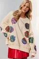Détail d'un sweat de Noël crème avec des motifs de boules de Noël en paillettes. - Abricot Avec Boule Multicolore