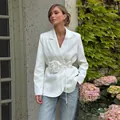 Close-up of elegant white blazer featuring a large 3D flower decoration and waist tie. - S / Tops / White