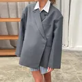 Detail view of a gray oversized blazer featuring a unique diagonal placket design. - S / Tops / Gray