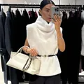 Elegant white faux fur vest with turtleneck and slim black belt for chic winter style - S / Tops / White