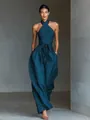 Elegant teal linen halter neck jumpsuit featuring cross straps and a wide leg fit on model - XS / Blue