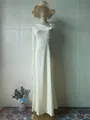 Elegant ivory satin long sleeve evening gown with pleated bodice on a mannequin - Light Yellow