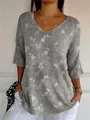 Close-up detail of women's gray V-neck T-shirt with elegant white floral vine print - S / Tops / Pattern 5