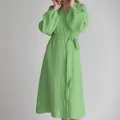 Close-up detail of a light green gauze wrap dress with smocked elasticated cuffs. - Yellow-Green