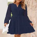 Dettaglio dell'abito blu navy con scollo a V, ricamo a occhielli e maniche lunghe. - Blu navy