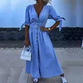 Detail van een lichtblauwe denim maxi-jurk met V-hals, knoopsluiting en strikmouwen. - S / Dresses / Saffierblauw