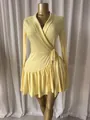 Dettaglio di un elegante abito a portafoglio giallo a maniche lunghe con bordo a pieghe - Giallo brillante