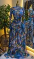 Gedetailleerd zicht op de bloemenprint van een elegante geplooide maxi-jurk met lange mouwen. - S / Dresses / Blauw