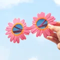 Primo piano di occhiali da sole a margherita rosa per bambini contro il cielo - Occhiali Stile Margherita Rosa / Rosa