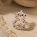 Detail van elegante kalebasbroche met roze bloemige strass-steentjes en groene bladeren - Strass Florale Kalebas Brosche