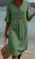 Detail of green linen dress with decorative buttons and ruffle sleeves at the beach. - S / Dresses / Green