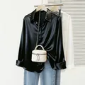 Gros plan sur un chemisier en satin noir avec col élégant et une finition brillante - 1XL / Hauts / Noir