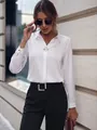 Vista detallada de blusa blanca elegante de manga larga usada por mujer profesional - Verde matcha