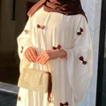 Elegant detail of white dress with brown bow embellishments and a pearl beaded bag. - One Size / Dresses / White with Brown Bow