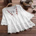 Close-up detail of white bohemian cotton blouse with floral embroidery and lace - S / Tops / White