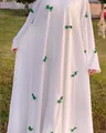 Detailed view of elegant white maxi dress featuring green bow accents and flare sleeves. - One Size / Dresses / White with Green Bow