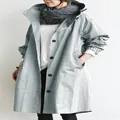 Detailaufnahme eines lässigen, mittellangen Kapuzen-Windbreakers in Hellgrau - Hellblau