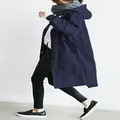 Seitenansicht eines mittellangen dunkelblauen Damen-Trenchcoats mit Kapuze und Tunnelzug. - Marineblau