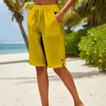 Détail du short jaune en coton et lin pour femme sur une plage tropicale - Jaune