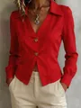 Detail view of a red long-sleeved professional blouse featuring large gold buttons. - Red