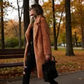 Detailed lifestyle view of woman wearing a long brown teddy fleece coat in autumn - S / Tops / Caramel color