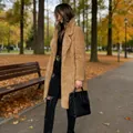 Stylish women's long sleeve lapel teddy coat fuzzy jacket shown in an outdoor autumn setting - Dark Camel