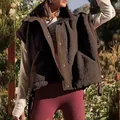 Detail view showing the warm texture and snap buttons of a brown sherpa fleece vest - S / Tops / Coffee