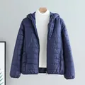 Marineblaue leichte Steppjacke für Damen mit Kapuze und schmal geschnittenem Stil - M / Oberteile / Marineblau