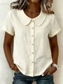 Close-up of a cream cotton linen blouse featuring a Peter Pan collar and pearl buttons. - S / Tops / Apricot