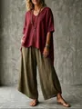 Full-length view of woman in wine red V-neck blouse and olive wide-leg pants - Burgundy
